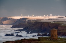 The octagonal 'Temple of the Winds' at Bude, North Cornwall, modelled on the 'Tower of the Winds' in Athens, was built by Bude's famous Acland Family in 1840 and moved to the present location in 1880. The headland is now known as 'Compass Point' after the markings of the cardinal and ordinal directions on its exterior walls. It provides a good source of foreground interest in any shot up the coast from here, though the light and drama is rarely as good as in this shot. At low tide an unbroken beach leads all the way up to the sunlit headland; behind it, and greatly foreshortened in this scene, the radar dishes of GCHQ Bude, built on the former WWII airfield of RAF Cleave, lie nearly 8km up the coast. A big Atlantic winter storm was hitting the coast, and it was this that I had gone out to photograph at dawn; I was not aware until I got there that snow had fallen in the night, and was fortunate to get the sun coming through to light it, and the radar dishes, during an all too brief break in the clouds.